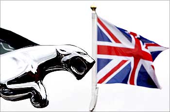 The British flag flies behind a Jaguar car emblem outside a dealership in Manchester.