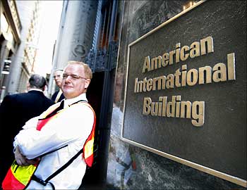 A security guard greets workers outside the AIG headquarters in New York.