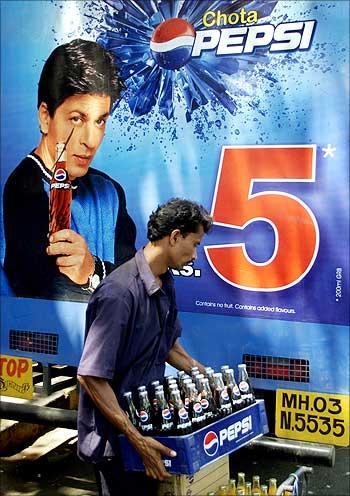 An Indian worker unloads crates of small Pepsi bottles in Mumbai.