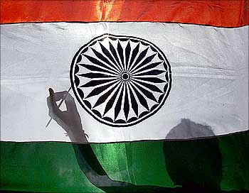 The shadow of a worker is seen as he gives finishing touches to an Indian national flag in Siliguri.