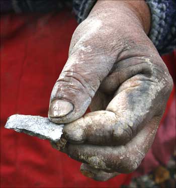 Bolivian indigenous woman Felipa holds a piece of silver ore in Potosi.