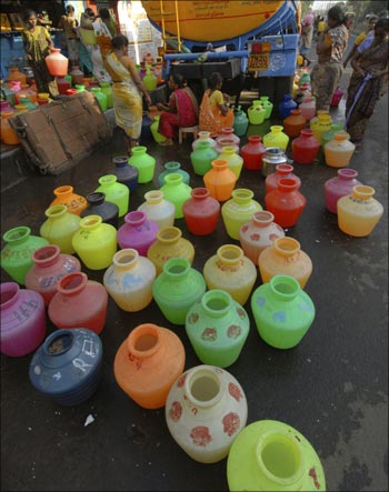 Women wait to fill their containers with drinking water supplied from the municipal corporation tanker.