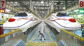 A labourer cleans the floor beside a China Railway High-speed (CRH) train preparing for the operation ceremony from Wuhan to Guangzhou in Wuhan, Hubei province.