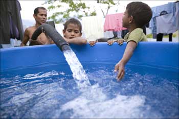 Children fill a water tank as the local government has called for water conservation, citing low rainfall caused by the El Nino weather phenomenon resulting in critically low water levels in the country's dams.