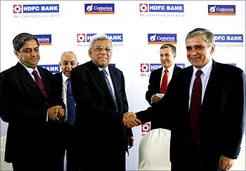 Deepak Parekh, chairman of HDFC Bank, shakes hands with Rana Talwar, chairman of Centurion Bank of Punjab, in Mumbai.