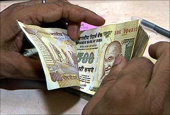 Cashier counts currency notes inside bank in Lucknow.