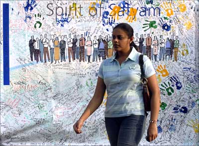 An employee walks past a banner with signatures of employees expressing the spirit and unity at the Satyam Computer Services head office in Hyderabad.