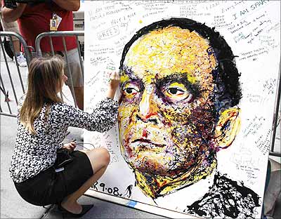 A Lehman Brothers Holdings Inc employee writes a message on a portrait of Dick Fuld in New York