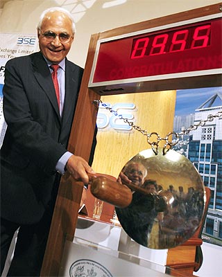K.P. Singh, chairman of real estate firm DLF Ltd. strikes a gong during the listing ceremony of DLF