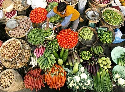 A vendor arranges vegetables at a market in Siliguri.
