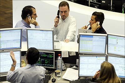 Traders talk on their phones at the Frankfurt Stock Exchange.