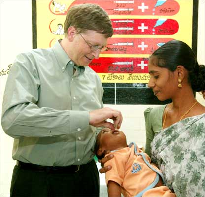 Bill Gates gives an oral polio drop to a baby at a health clinic in Andhra Pradesh.
