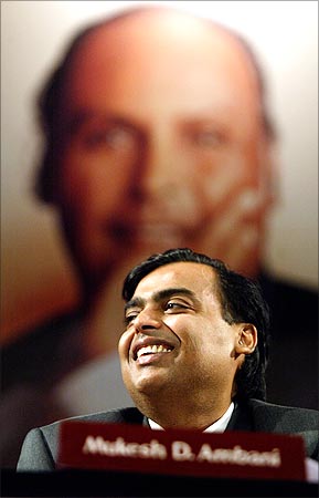 Reliance Industries chairman Mukesh Ambani, with the image of his father Dhirubhai Ambani in the backdrop.