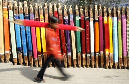 Image: A labourer carries a roll of cloth at a roadside dye factory in Siliguri. Photograph: Rupak De Chowdhuri/Reuters