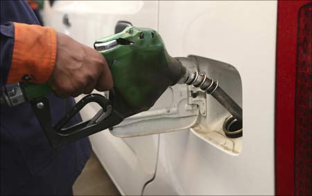 An employee fills a car with petrol at a gas station in Jammu.