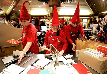 People dressed as elves postmark letters with the stamp from Santa Claus' Post Office on the Arctic Circle near Rovaniemi, northern Finland.