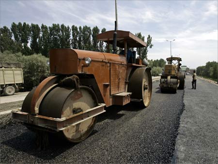 Workers use road rollers during the rebuilding process of a road.