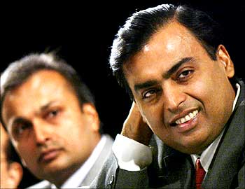 Mukesh Ambani (R) and Anil Ambani listen to a shareholder speak during the company's Annual General Meeting (AGM) in Bombay June 24, 2004.