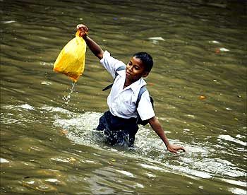 A school boy struggles to balance himself on a flooded street in Mumbai on July 4, 2009.