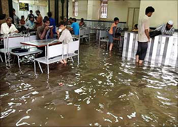 Men eat inside a flooded restaurant in Mumbai.
