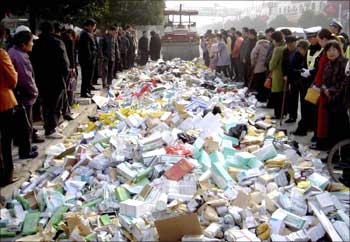 A steamroller destroys fake medicine as locals watch in Suqian, China.