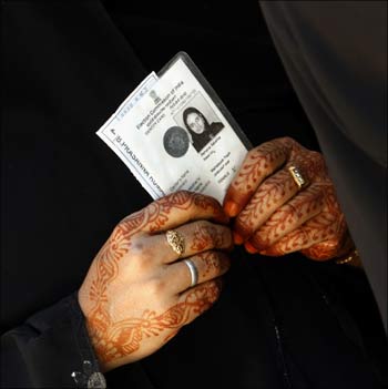 A woman holds her voter's identity card at a polling booth in Bangalore.
