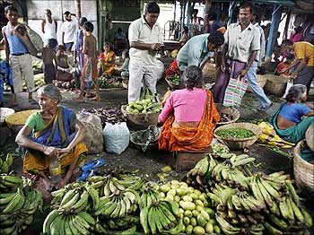People crowd at a wholesale vegetable market.