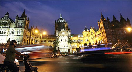 A scooterist stops in front of Chhatrapati Shivaji Terminus railway station, also known as Victoria Terminus, in Mumbai.