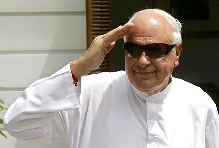 Farooq Abdullah gestures as he arrives to attend the United Progressive Alliance (UPA) meeting.