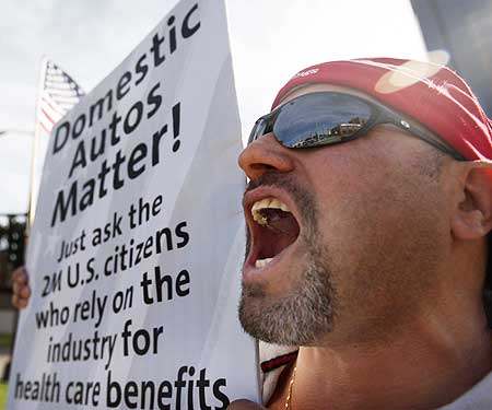 Employee Manny Salazar protests job losses at General Motors, which enters the list as the fourth largest bankrupt company in the US.