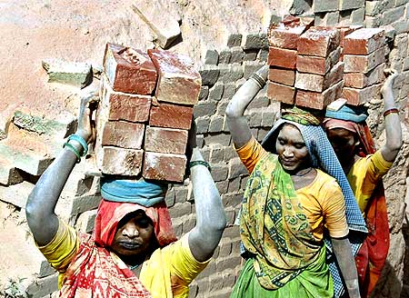 Labourers carry bricks on their heads at a brick kiln at Kodhasar, south of Allahabad.
