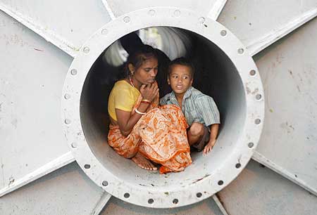 A homeless woman and her son take shelter inside a pipe in Kolkata.