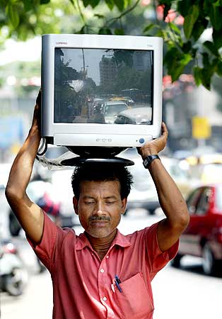 A worker carries a new computer terminal to an office.