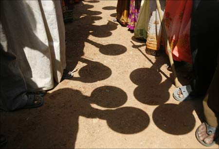 Villagers hold empty plates as they stand in front of the office of a block development officer in Galsi village near Kolkata.