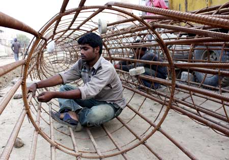 Labourers work at a commercial construction site in Ahmedabad.