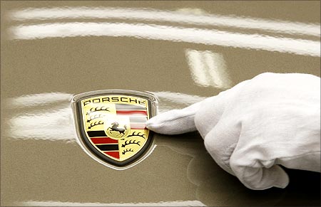 A worker inspects the logo on a car.
