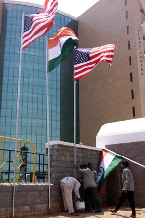Workers at 'High Tech City', a building where software companies are situated put up Indian and American flags in Hyderabad.