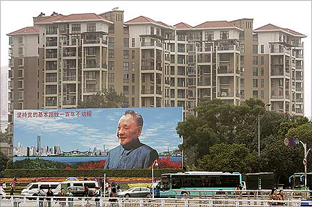Apartments are seen behind a billboard of late Deng Xiaoping in Shenzhen.