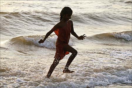 A tourist runs on a beach in the town of Velankanni near Chennai.