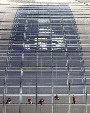 Workers clean the exterior of the National Grand Theatre, nicknamed the 'egg', in Beijing.
