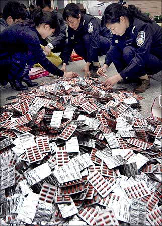 Police check confiscated fake drugs after they smashed a counterfeit gang in Xuchang, Henan province