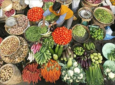 A vendor arranges vegetables at a market in Siliguri, West Bengal