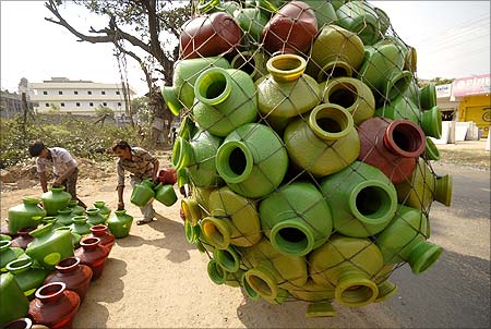 Roadside vendors unload plastic pitchers for sale from a vehicle on the outskirts of Hyderabad.