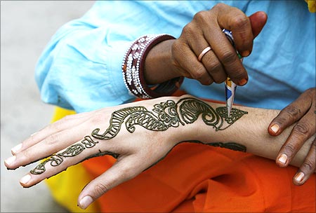 A vendor applies henna designs on the hand of a Kashmiri girl in Srinagar.