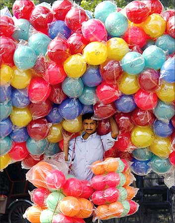A street vendor walks with plastic balls at a fair ground in New Delhi.