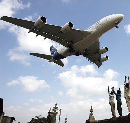 Children react as an Airbus A380 aircraft prepares to land at Mumbai airport.