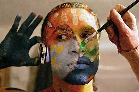 A model uses a mobile phone during a body painting show.