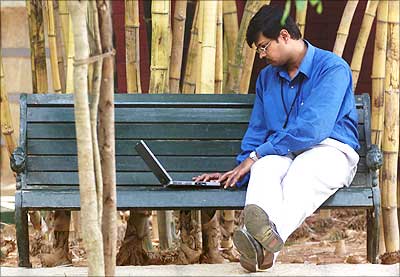 An Infosys employee works on his laptop during his lunch break.