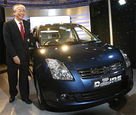 Shinzo Nakanishi, managing director of Maruti Suzuki, poses with a Maruti DZire.