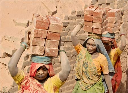 Labourers carry bricks on their heads at a brick kiln at Kodhasar village near Allahabad.